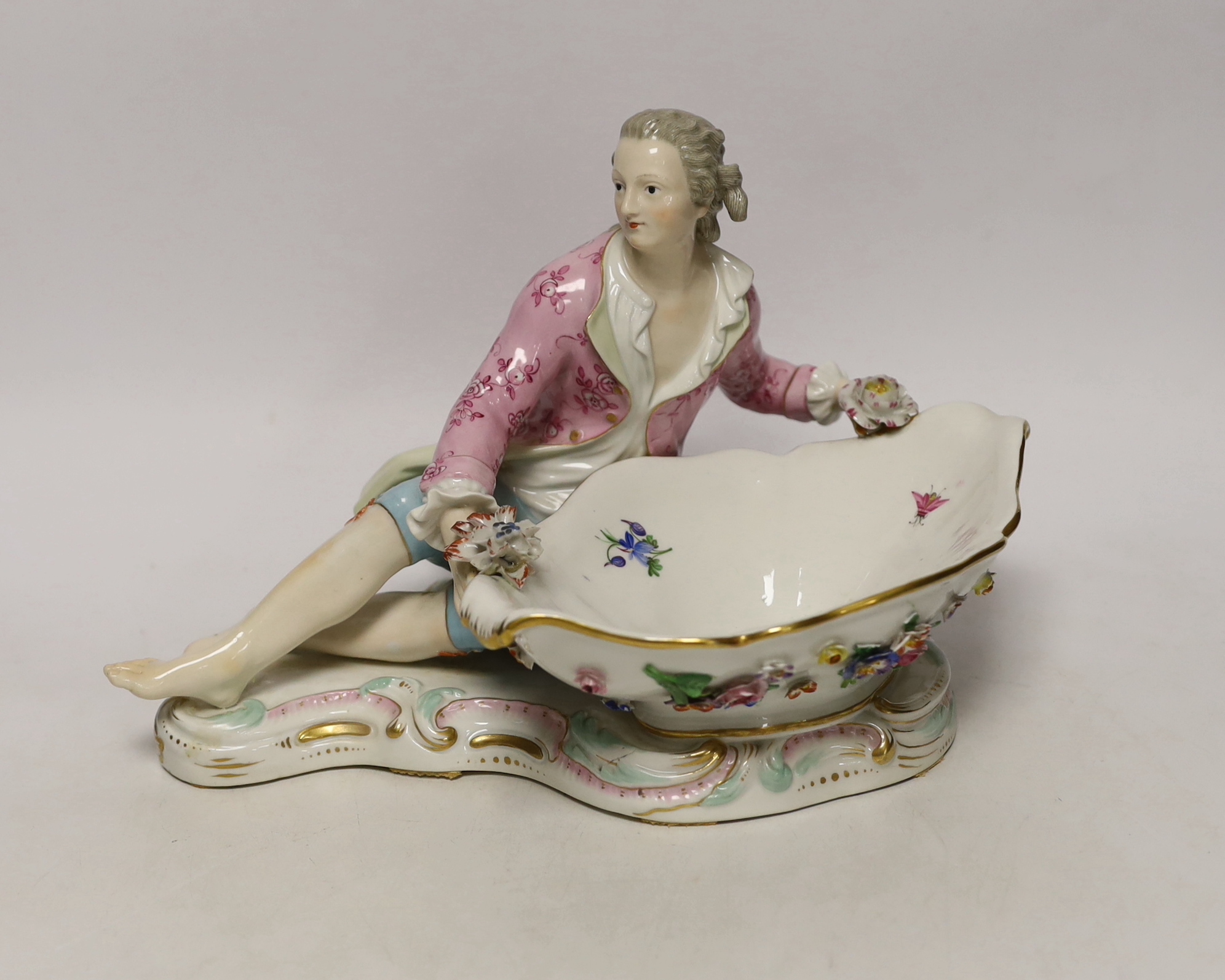 A 19th century Meissen figural sweetmeat dish with floral encrusted decoration, crossed swords mark to the base, 30cm wide